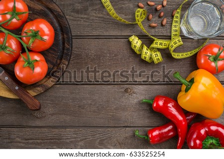 Sport and diet. Vegetables and centimeter. Peppers, tomatoes, salad on rustic background