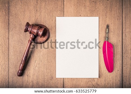 Auction or judge gavel, vintage red quill ink pen and textured paper blank on wooden table background. Retro old style filtered photo
