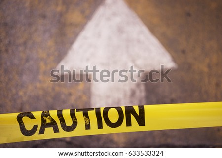 Yellow Caution Tape With Pointing Arrow Ahead Royalty-Free Stock Photo #633533324