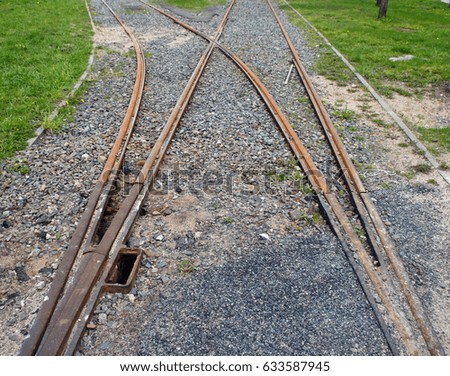 Rusty rails, grass, small pebbles
