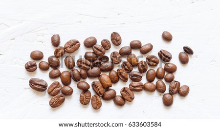 Roasted coffee beans on white wooden background