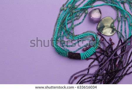Purple background with beads, mother of pearl heart pendant and amethyst gem stone