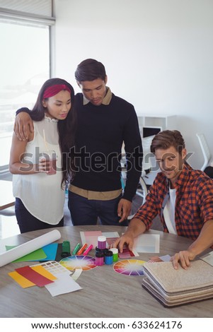 Young business colleagues discussing at creative office desk