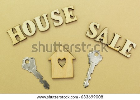 Wooden house and two keys, the inscription "sale house"