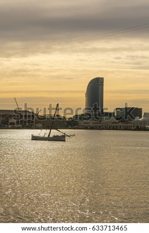 Sunrise at the port of Barcelona, at the end of the Ramblas. In the photo, a fishing boat and sailing hotel. Barcelona, Spain