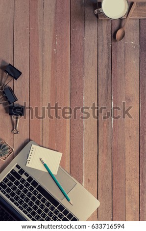 Office stuff and it gadgets display on top view business desk with copy space at text of picture. Creative table, modern project. Business mockup at empty laptop device on wood background.