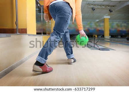Young man throwing ball in bowling club