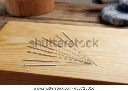 Acupuncture needles on wooden board