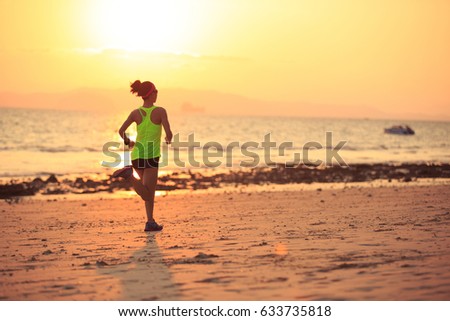 Healthy lifestyle young fitness woman running at morning beach 
