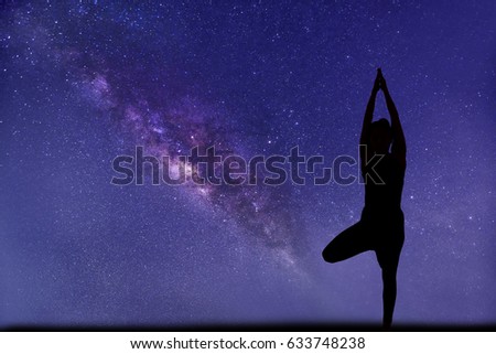 milky way, close up view. Professional woman yoga pose foreground.