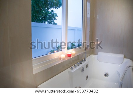 Square jacuzzi near window in luxury bathroom.