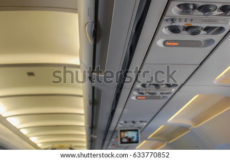 Plane's overhead console with air conditioning lighting television and no smoking sign