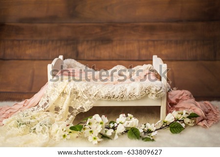 Newborn photo shoot set up with prop bed and wood backdrop Royalty-Free Stock Photo #633809627