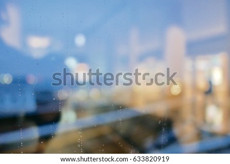 rain drop on clear glass window, reflection of blurred airport terminal and light bokeh from outside, beautiful color abstract for background