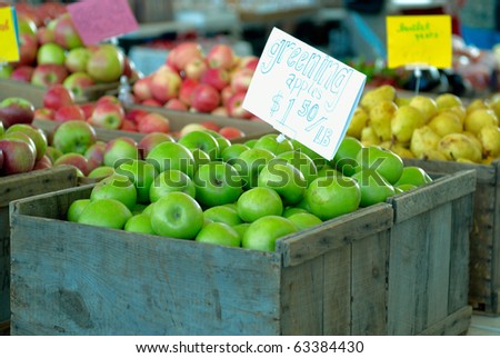 Ripe green apples in box with a price tag