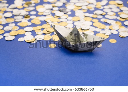Ship made of us dollars goes with the coins on blue background