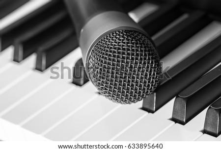 Musical concept image. Microphone over the piano keyboard. Image in black and white.