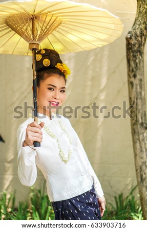 Northern Thai Women In Traditional Dresses  with Saa Paper Umbrella In Lanna New Year Festival, Chiang Mai, Thailand