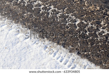   picture taken in winter after snowfall on a small rural road. Snow on the ground