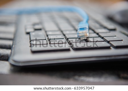 ethernet cable plug connector on computer laptop keyboard technology concept.