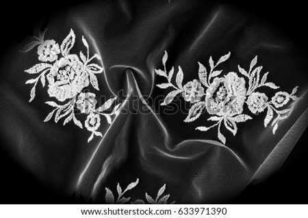 Texture, background, pattern. Lacy white fabric. Flowers made of lace fabric. Isolated black background. greeting card. Wallpaper for your desktop. Screensaver backdrop for designer