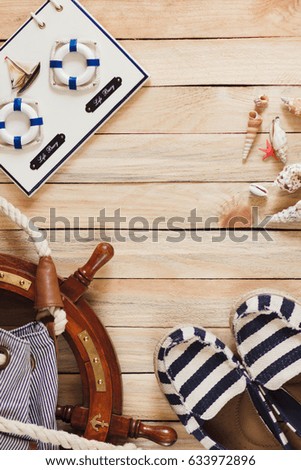 Striped slippers, bag and maritime decorations on the wooden background, top view