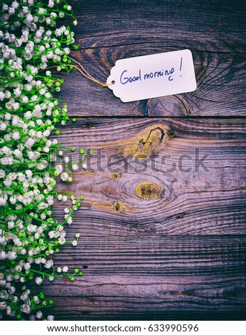 Gray wooden background with a paper tag with the inscription good morning, empty space at the bottom