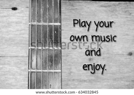 Wordings 'Play your own music' on background with a guitar