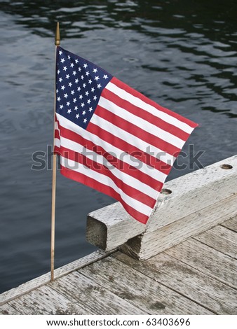 US flag welcoming arrivals on pier at Ketchican, Alaska. Royalty-Free Stock Photo #63403696