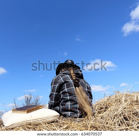 A girl on a straw stack