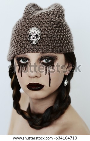 goth girl in hat with skull posing on white background