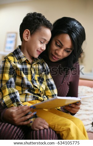 Young African American woman reading story her son.