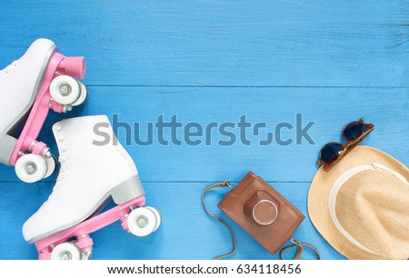 Sport, healthy lifestyle, roller skating background. White roller skates, retro camera, straw hat and retro sunglasses. Flat lay, top view.