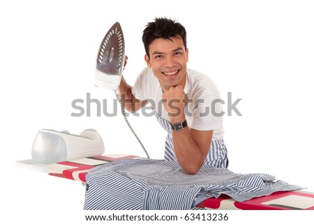 Young handsome Nepalese man against the ironing-board with iron in one hand. Studio shot, white background.