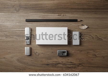 Bank business cards, pencil, eraser, flash drive and sharpener on wood table background. Photo of blank stationery set. Mock up for branding identity. Top view.