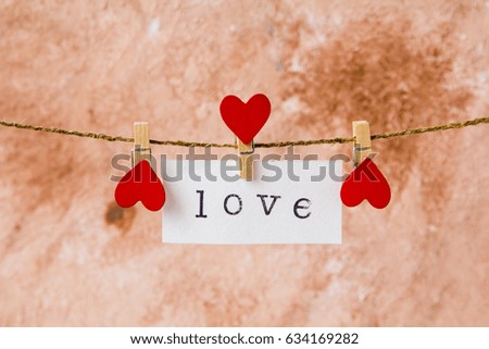 inscription love on white paper hanging on a rope with clothespin