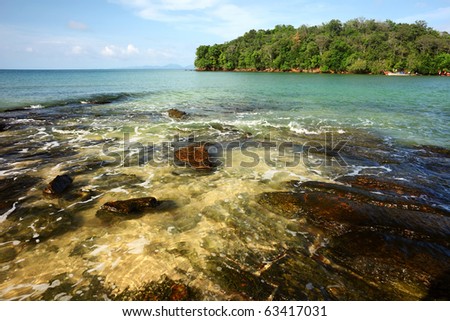 Rocky beach and island with trees in sea