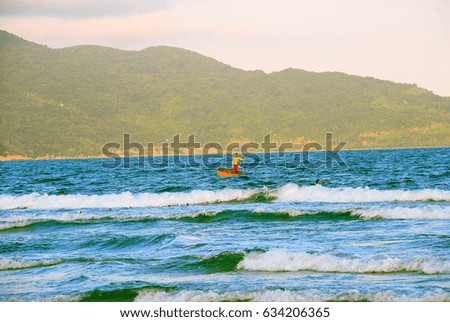 Man inside orange and circular boat sailing in the ocean