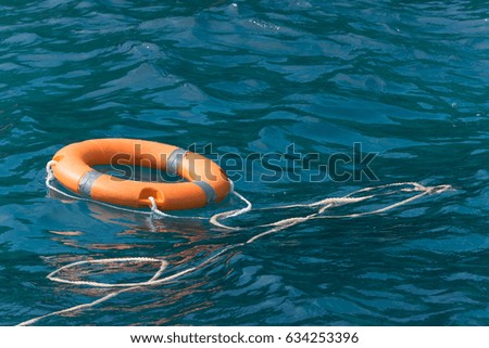 Lifebuoy (Safety Equipment) Tied with rope in The Sea for Snorkeling Diving tourists.