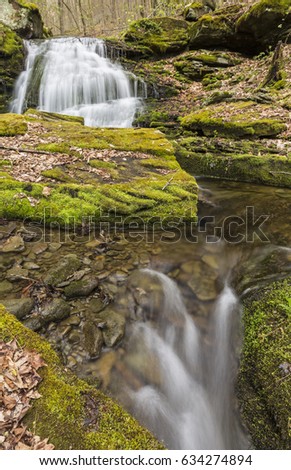 A double set of silky waterfalls surrounded by mossy rocks on a creek in Kelly Hollow in the Catskill Mountains of New York