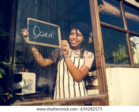 Woman Hanging Open Sign by the Glass Window