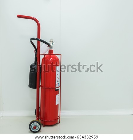 Red fire extinguisher in the light gray back ground clean room