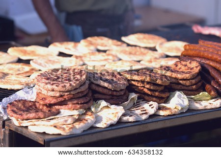 Grill on charcoal and flame, picnic, street food.Sausages and grilled meat and bread.Close up of hot cevaps, burgers and chicken meat prepared on barbecue