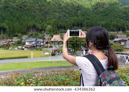 Woman taking photo on cellphone in miyama