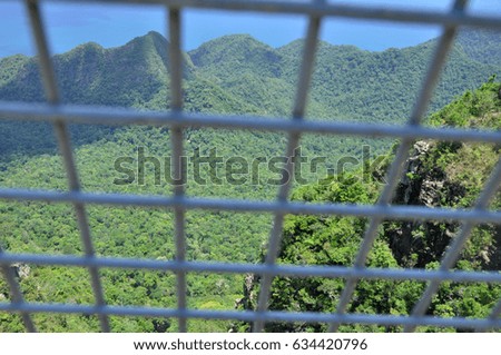 Cage in front of landscape of sky and mountain