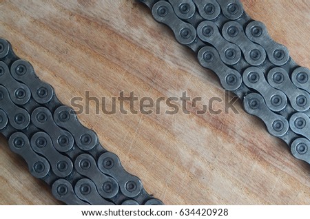 Dirty and oily chain from a mountain bike lying on a wooden table in a bicycle shop. One of the main elements of the transmission of torque on bikes and bicycles close up
