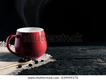 Coffee in red cup on old wooden table, vintage tone