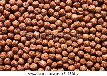 Chocolate breakfast cereal texture. Cereal balls as background. Chocolate corn balls wallpaper background cover. Cereals texture concept.