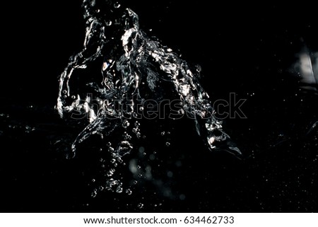 Bubbles, stream and splashes in aquarium on black background