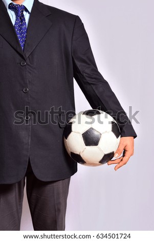 Businessman holding football ball